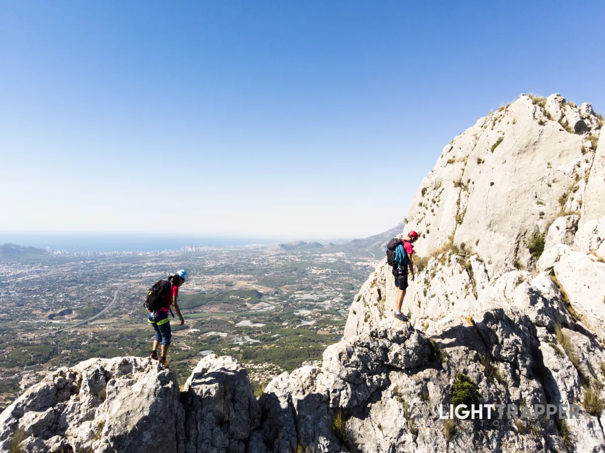 Two climbers proceeding on an exposed section of a ridge