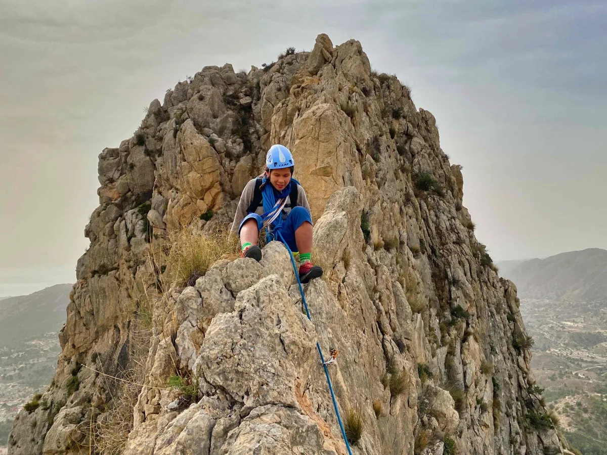 A climber sitting on top of knife edge ridge